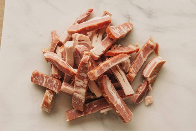 Lardons épais coupés sur planche à découper en bois