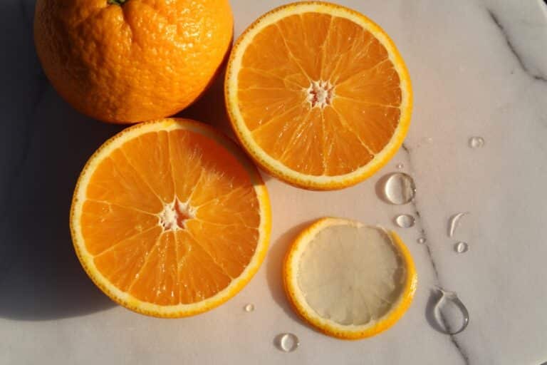 Oranges entières et tranchée montrant la pulpe juteuse