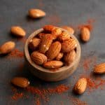 Bouchées noix de coco et amandes enrobées de coco râpée sur assiette blanche