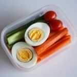 Œuf dur coupé en deux avec crudités dans un contenant à emporter