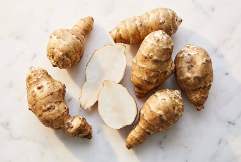 Topinambours entiers et tranchés sur marbre blanc