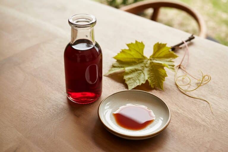Carafe de vinaigre de vin rouge avec raisins rouges