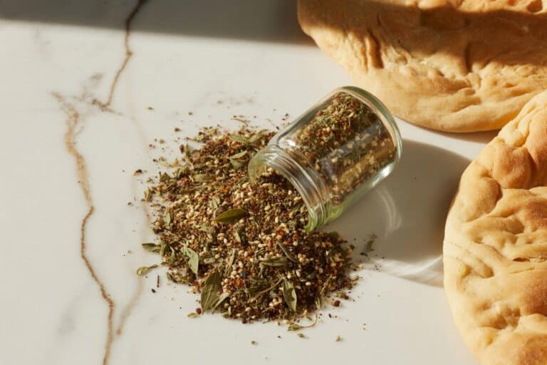 Mélange za'atar étalé sur marbre avec pain plat